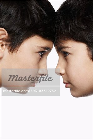 Twin boys (13-15) head to head, close-up