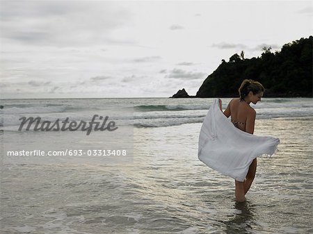 Jeune femme patauger dans l'océan