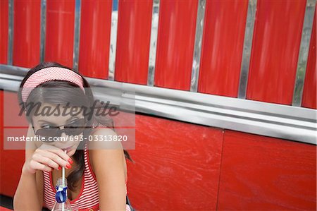 Junge Frau trinkt eine Soda