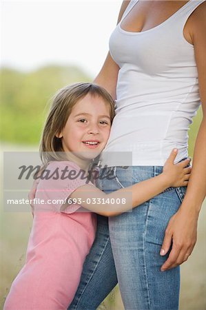 Kleines Mädchen umarmt ihre Mutter