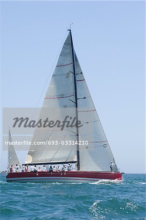 Triangular sail on yacht in competitive team sailing event, California