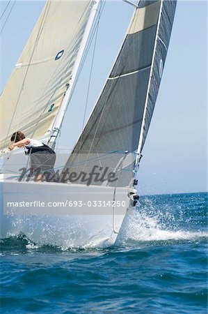 Crew member on board yacht competing in team sailing event, California