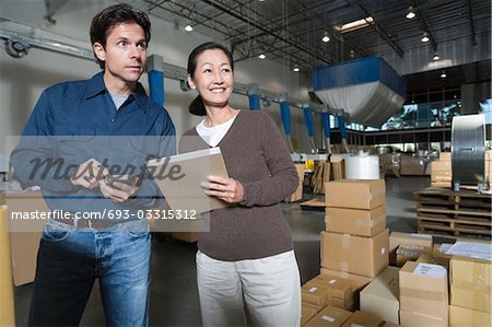 Homme et femme dans l'entrepôt de distribution