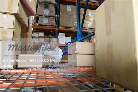Man stacking boxes in distribution warehouse