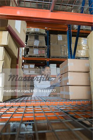 Man stacking boxes in distribution warehouse