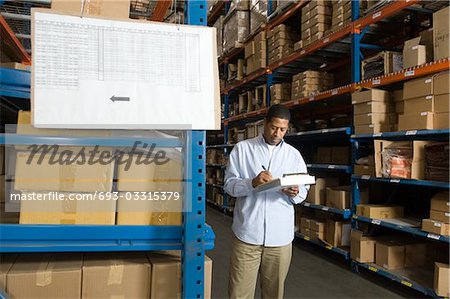 Man inspecting boxes in distribution warehouse