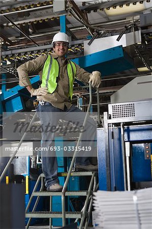 Man working in factory, on steps