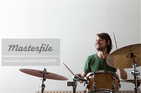 Young man plays drums with enjoyment