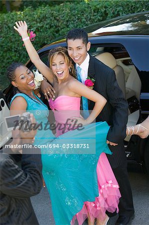 Well-dressed teenage couples posing an video taping selves outside