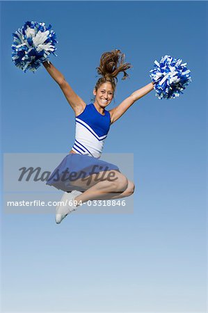 Lächelnd Cheerleader springen in Luft, (Portrait), (low Angle View)