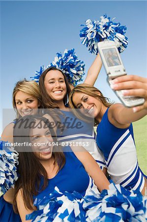 Cheerleaders photographing self with camera phone
