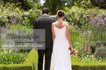 Mariée et le marié marche à vue jardin, dos