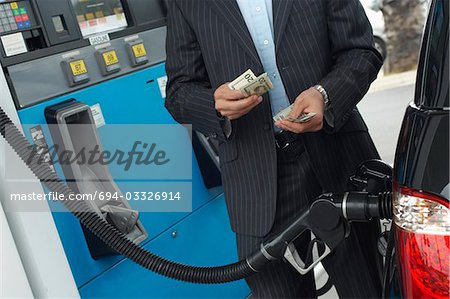 L'homme argent comptant plus de pompe à essence en voiture, en moyenne section