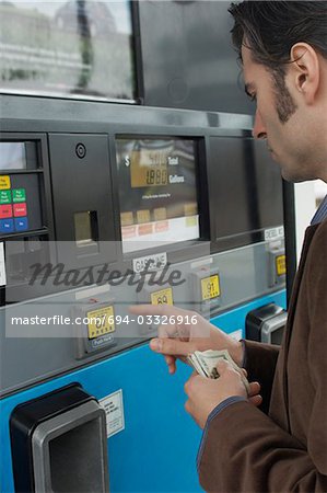 Man pushing buttons on gas pump