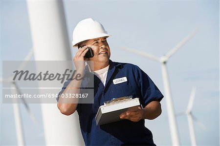 Ingénieur à l'aide du téléphone mobile au parc éolien
