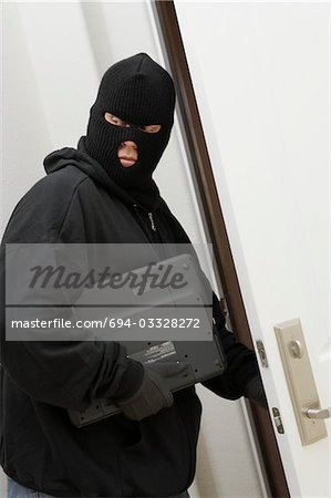 Burglar stealing laptop