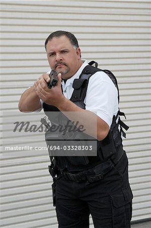 Portrait de gardien de sécurité en gilet pare-balles détenant des armes à feu