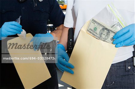 Officier de police, mettre de l'argent dans l'enveloppe de preuve