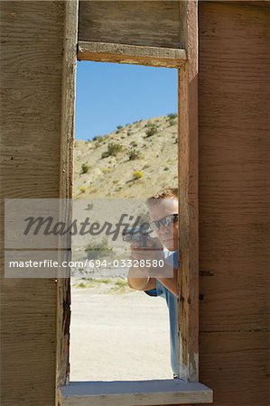 Man aiming hand gun at firing range
