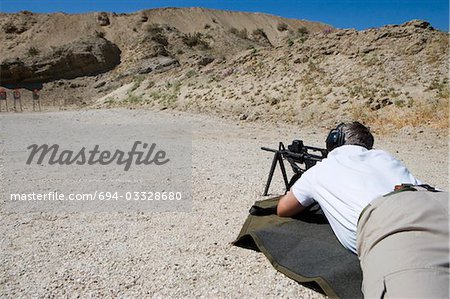 Man aiming machine gun at firing range