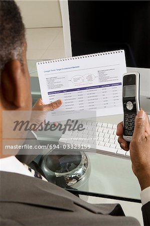 Homme d'affaires avec investissement Brochure et téléphone cellulaire