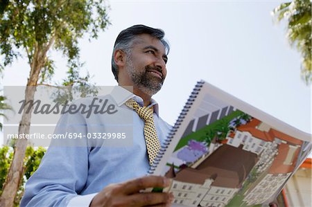 Architect Holding Book with Building Plans