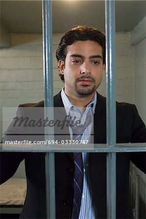 Mid Geschäftsmann stehend hinter Gittern Zelle