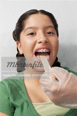 Nurse checking girls tongue in hospital