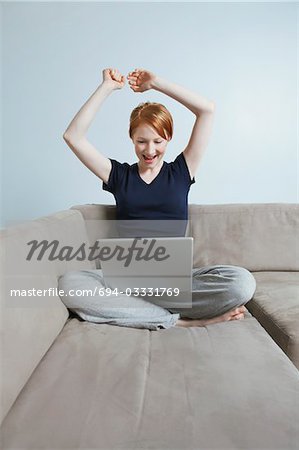 Femme utilisant un ordinateur portable sur le canapé