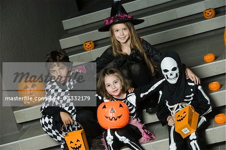 Portrait of boys and girls (7-9) wearing Halloween costumes on steps