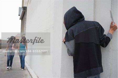 Voleur avec couteau caché derrière le coin et d'attendre que deux jeunes filles