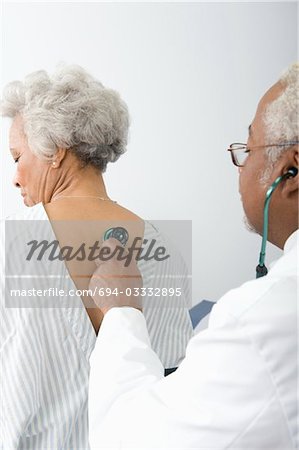 Senior practitioner listens to breathing through stethoscope