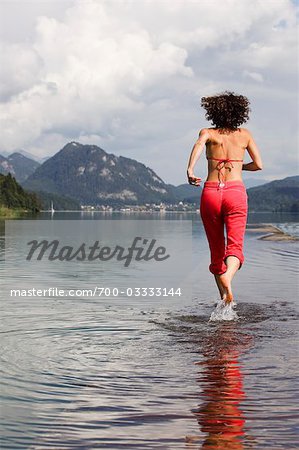Femme traversant superficielle eau, Fuschlsee, Salzbourg, Autriche