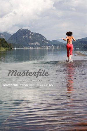 Woman Running Through Shallow Water, Fuschlsee, Salzburg, Austria,