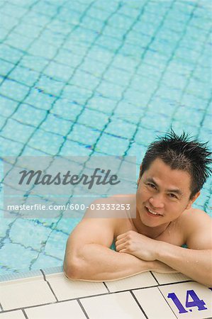 Homme s'appuyant sur le bord de la piscine