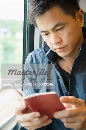 Man Reading Book on Train