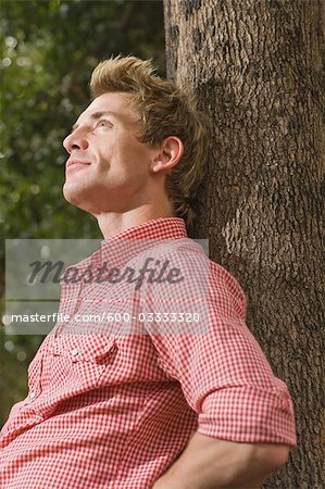 Daydreaming Man Leaning Against Tree