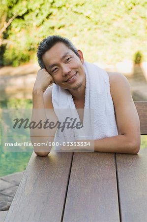 Man Sitting at Table Smiling with Head Leaning on Hand