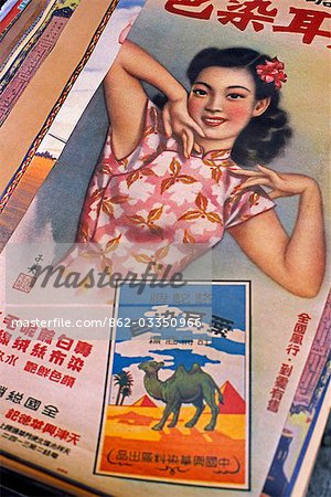 Une affiche pour un voyage exotique se trouve parmi les antiquités et objets de curiosité sur le marché de rue de chat dans le quartier de Sheung Wan, Hong Kong