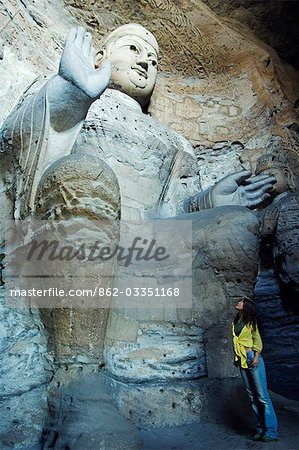 China, Provinz Shanxi Datong. Chinesische Mädchen Blick auf buddhistische Statuen des Yungang Grotten Schnitt während der nördlichen Wei-Dynastie (460 AD). UNESCO-Weltkulturerbe in der Nähe von Datong.