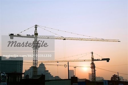 China,Beijing. Sunset over a construction site's cranes.