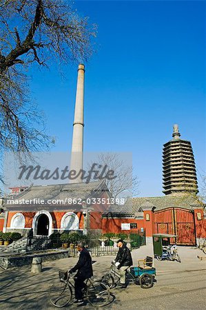 Temple de Chine, Beijing, Tianningsi. Cyclistes en passant un temple et une cheminée.