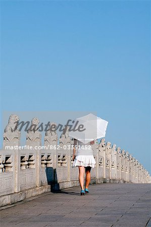 China, Peking. Sommerpalast - Unesco Weltkulturerbe. Ein junges Mädchen auf die 17 Bogenbrücke.