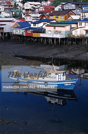 Fishing boat in front of brightly painted palafitos
