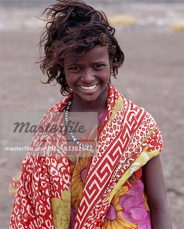 Une joli créer-fille aux cheveux de la tribu nomade des Afars porte des couleurs vives en contraste avec les environs de couleur ternes, balayées par les vents du lac Abbe.