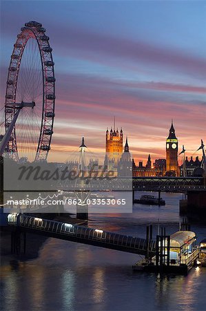 Das London Eye, Big Ben und den Houses of Parliament, die über die Themse von Waterloo Bridge bei Sonnenuntergang gesehen. Hungerford Bridge steht im Vordergrund.