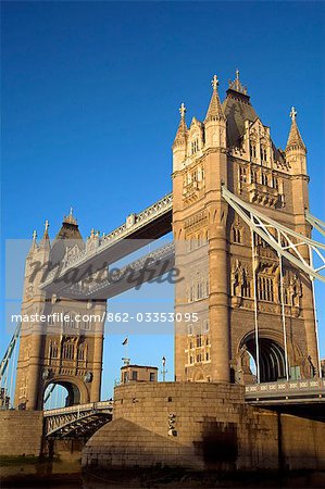 Tower Bridge à l'aube. Construction du pont a commencé en 1886 et a duré 8 ans. La travée centrale peut être déclenchée pour permettre aux navires de voyager vers l'amont. Le pont se trouve à proximité de la tour de Londres, qui lui donne son nom. Il est souvent confondu avec le pont de Londres, le prochain pont en amont.