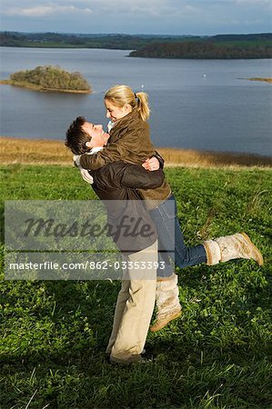 UK,Northern Ireland,Fermanagh. A couple embrace on a walk overlooking the lake at Lough Erne Golf Resort .