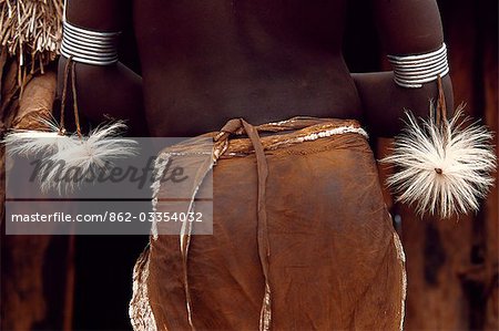 A young girl of the Karo tribe has attached tassles of cowskin to her steel amulets. She wears a skirt of calfskin edged in metal beads. A small Omotic tribe related to the Hamar,who live along the banks of the Omo River in southwestern Ethiopia,the Karo are renowned for their elaborate body painting using white chalk,crushed rock and other natural pigments.