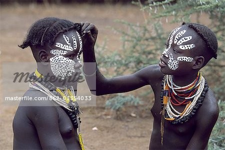 Une jeune fille de Karo décore son visage les amis. Une petite tribu Omotic associés à Hamar, qui vivent le long des rives du fleuve Omo en Éthiopie le sud-ouest, le Karo sont renommés pour leur peinture sur corps élaborés à l'aide de craie blanche, la pierre concassée et autres pigments naturels.